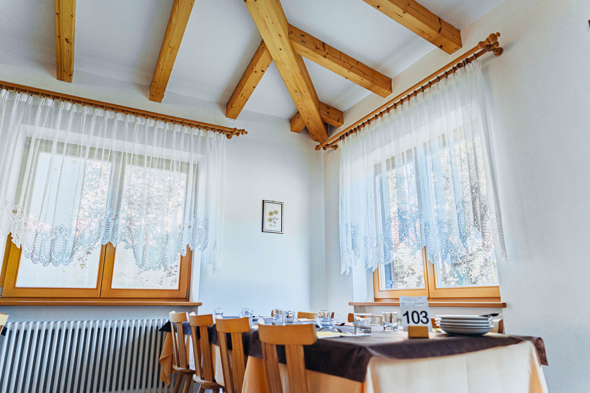 Dettaglio della sala con travi a vista e finestre